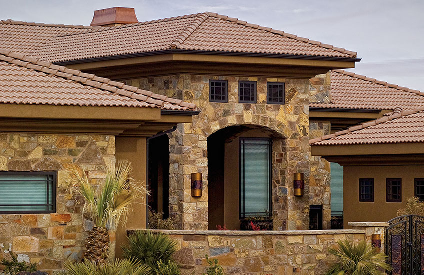 Eagle Malibu Roof Stucco home with clay roof tiles, arched entry, and manicured landscaping.