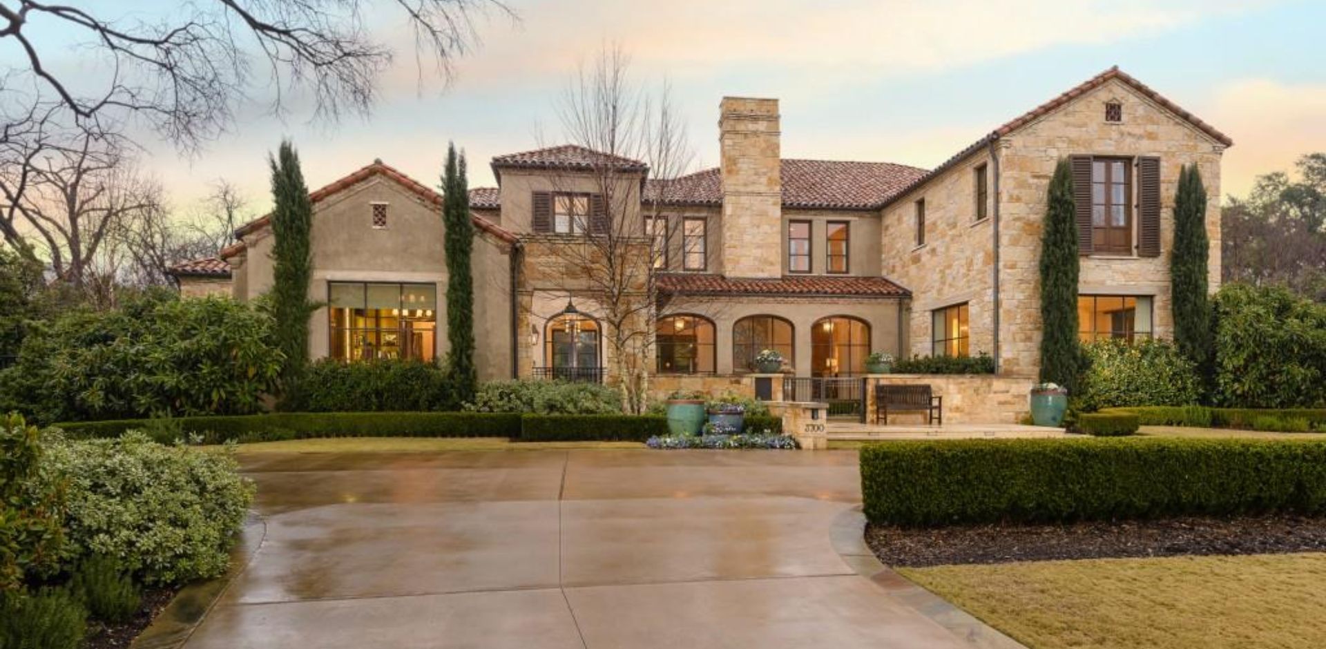 Elegant Tuscan-style estate with natural stone walls and red clay roof tiles.