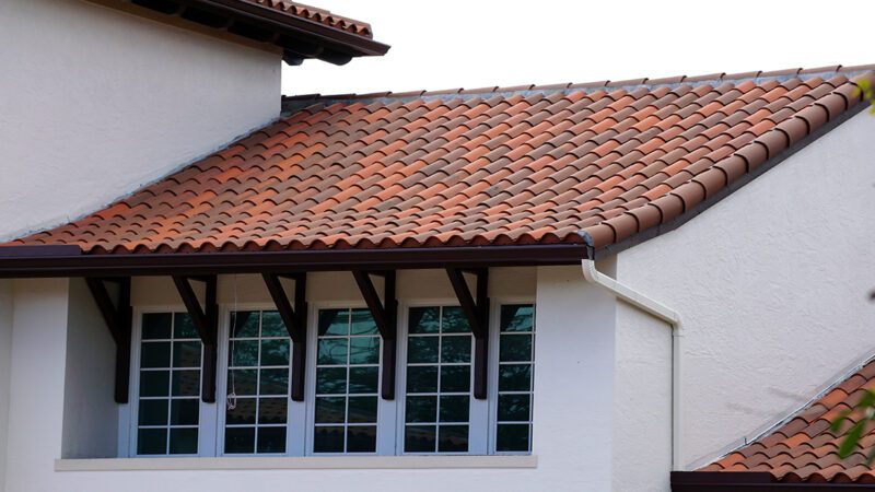 Spanish "S" Clay Tile Close-up of curved red barrel clay roof tiles on a white stucco home.