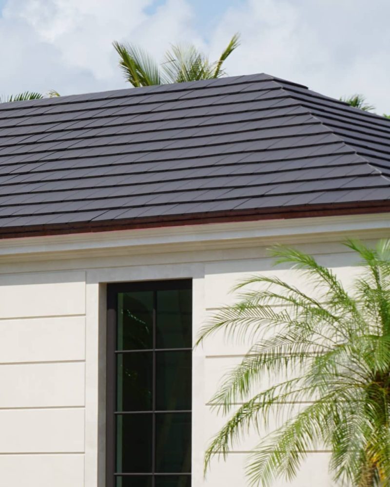 Modern home with smooth flat gray clay roof tiles and white stucco exterior.