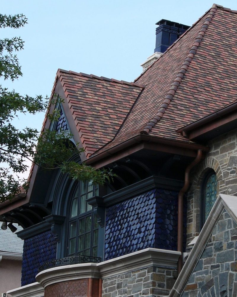 European-style heritage home with multi-toned clay roof tiles and blue decorative wall tiles.
